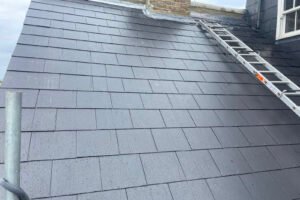Professional roofer installing new roof tiles on residential property in London, showing expert craftsmanship and safety standards